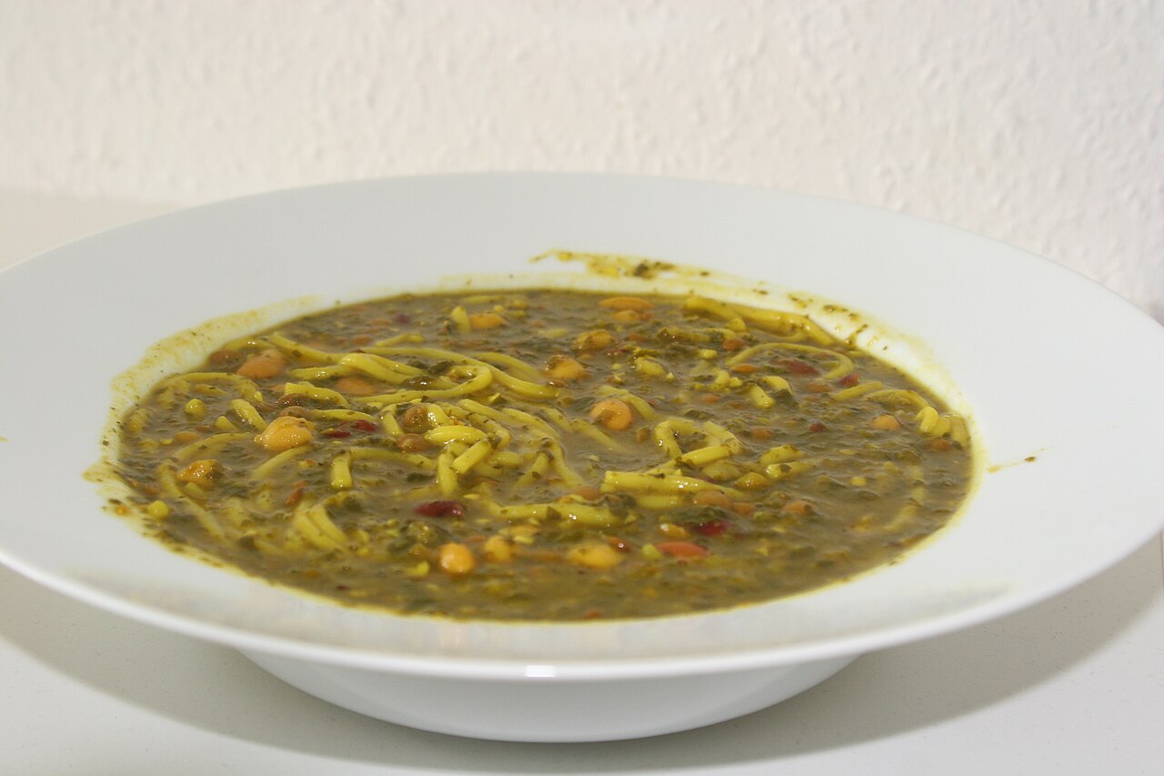 Āsh‑e reshteh — the chickpea, lentil, bean and herb noodle soup of every Iranian winter.