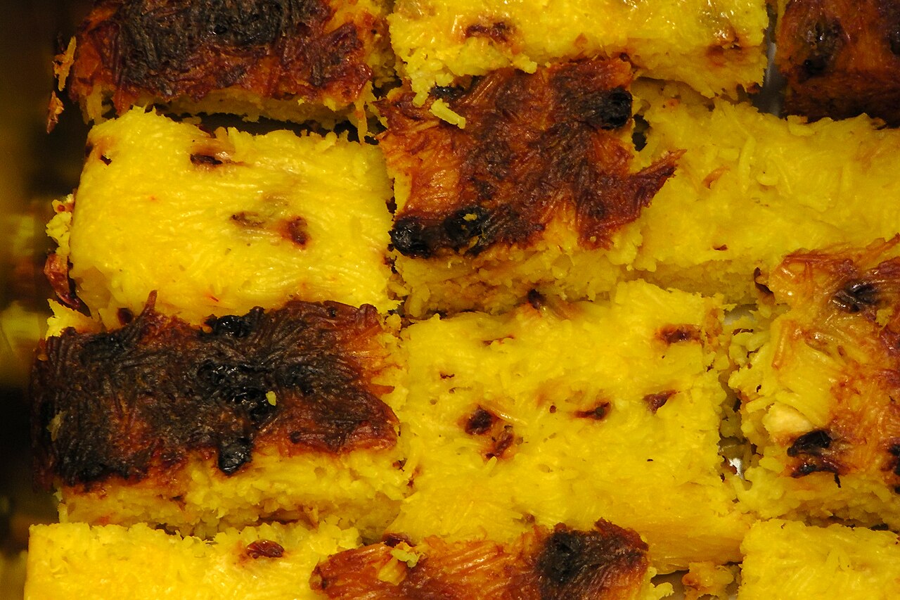 Tahchin — a saffron-yogurt rice cake unmoulded at the table.