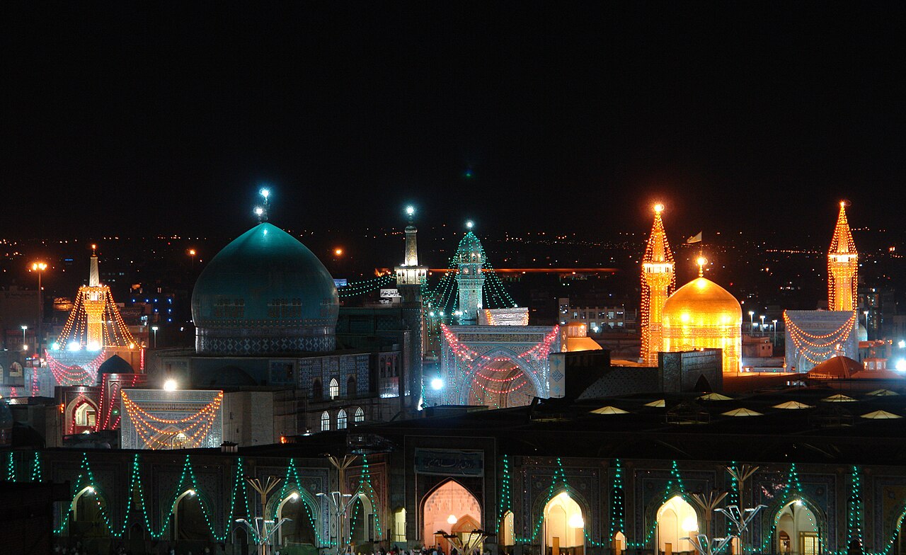 The golden dome of the Imam Reza Holy Shrine in Mashhad at twilight.