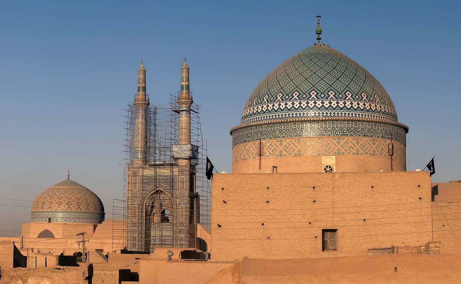The badgir-studded skyline of Yazd at sunset — an unbroken sea of mud brick.