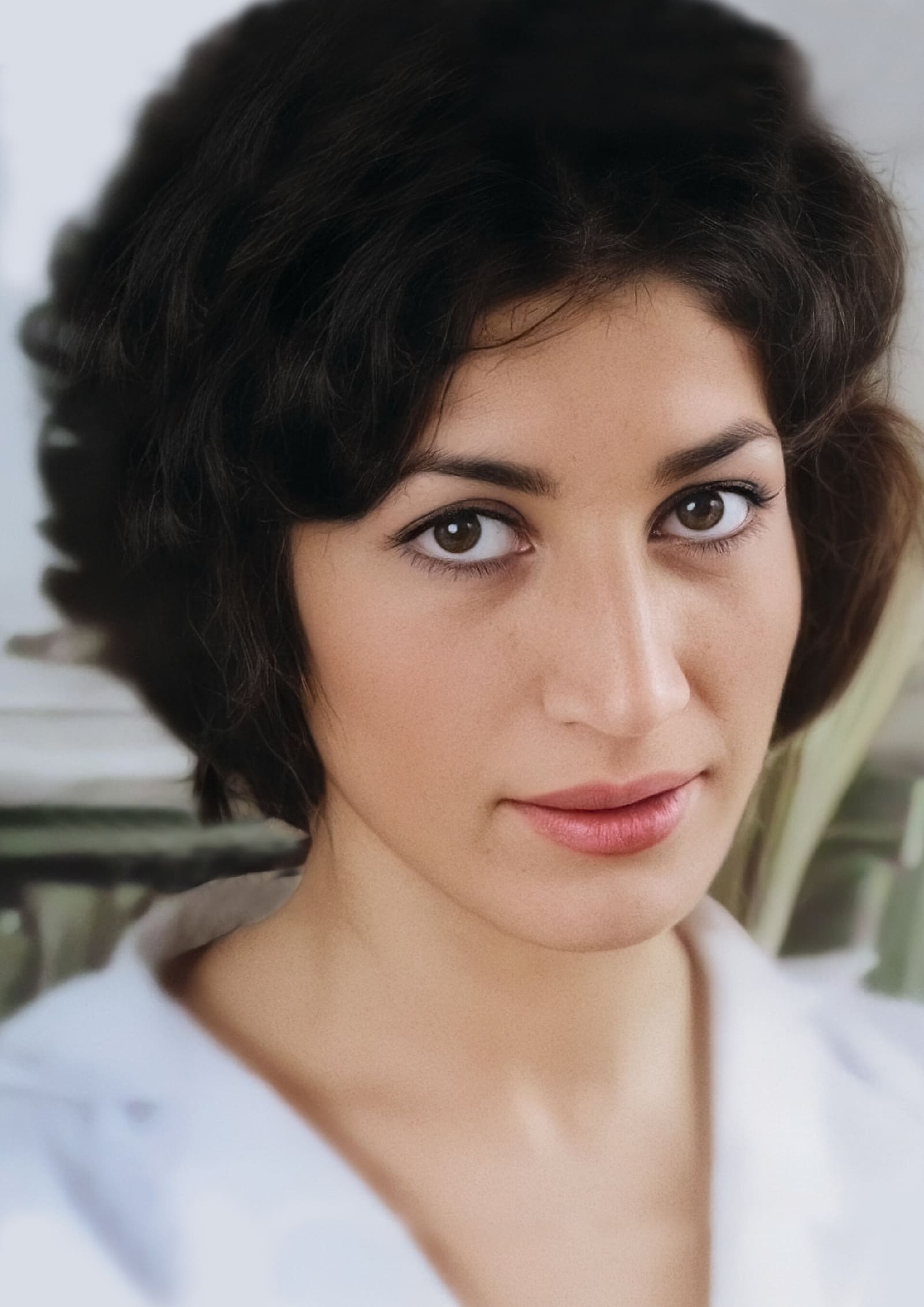 A black and white studio portrait of the Iranian poet Forough Farrokhzad circa 1965, looking thoughtfully towards the camera with a confident and modern presence.