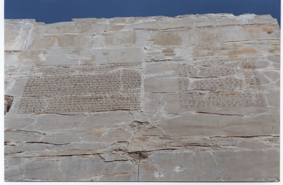 Close-up of a trilingual cuneiform inscription of Xerxes I carved into the Gate of All Nations at Persepolis, showing Old Persian, Elamite, and Babylonian texts.